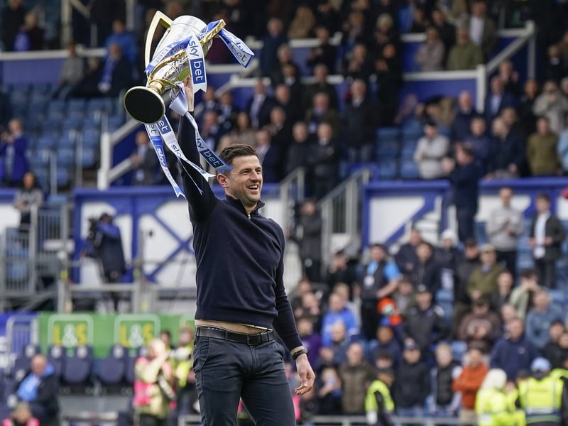 The gaffer celebrates with the silverware against Wigan.