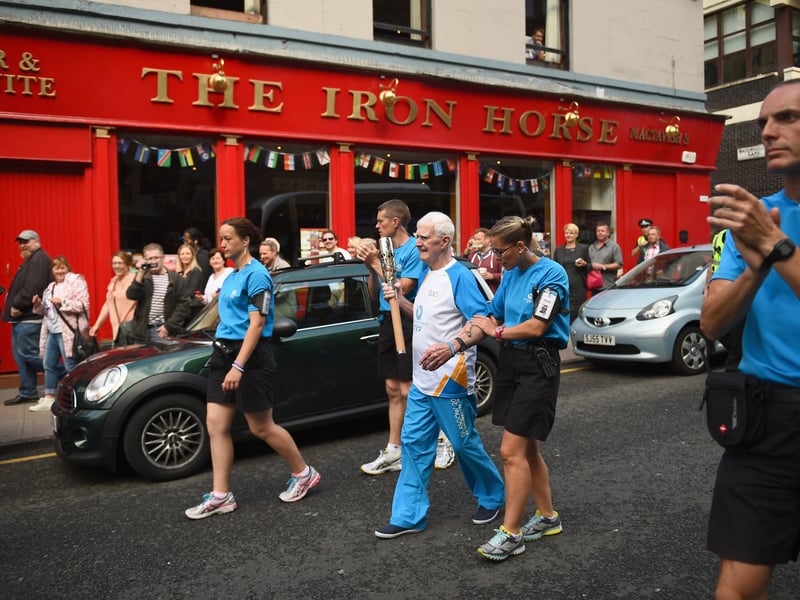 A total of 400 people carried the Queens Baton Relay around Glasgow ahead of the Commonwealth Games opening ceremony at Celtic Park. Pictured here is William Don heading down West Nile Street past The Iron Horse pub which used to be a favourite haunt of Scotland fans. 