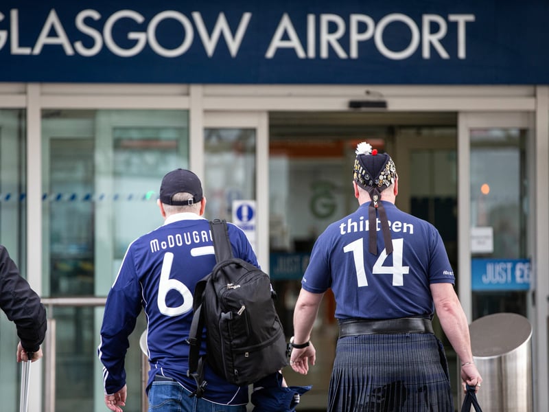 Two Scotland fans head for the departure lounge at Glasgow airport.