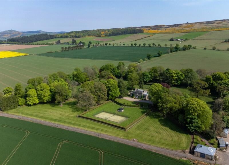 Externally the 12 acres of grounds include two paddocks, front and back, and steps down from the top garden to a tennis court.”
