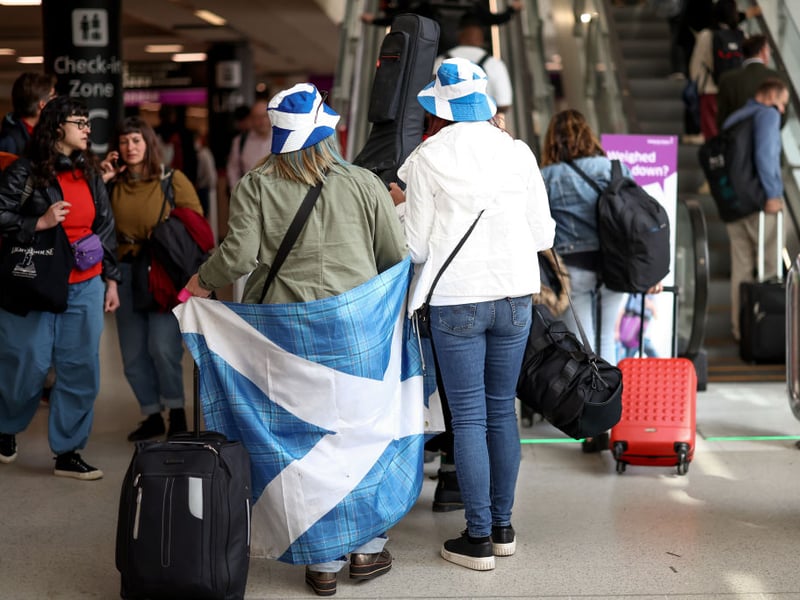 Two fans prepare to head to Euro 2024 with their flag in hand.