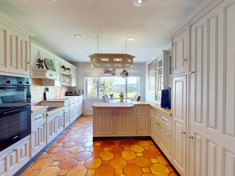 The family style breakfast kitchen is fitted with an extensive range of fitted wall and base cabinets with predominantly tiled working surfaces over, incorporating a sink and drainer, and integrated appliances include an electric double oven, ceramic hob, fridge/freezer and a dishwasher.