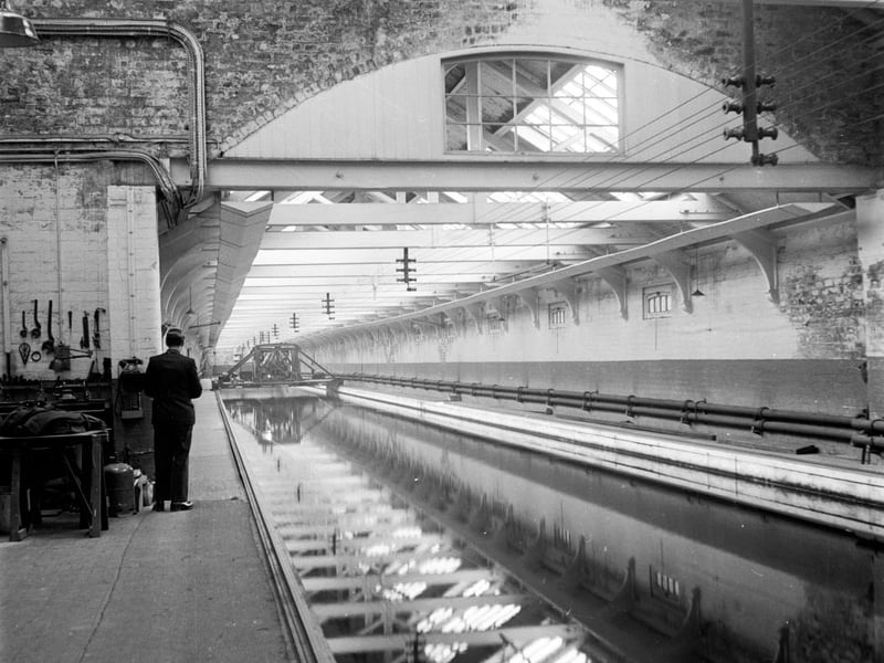 The long testing tanks for liners and other vessels at John Brown's shipyards on the Clyde, Glasgow. Workers construct a 'miniship', an exact model of the loaded merchant ship it is representing, so they can test the vessel's specifications in the tank.