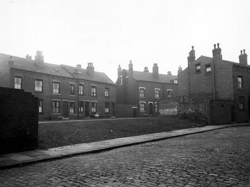 Road in the foreground is Flaxton Terrace, showing space where houses once were. In the background can be seen houses on Fulham Street, with a perambulator outside one of the doors. Pictured in October 1949.