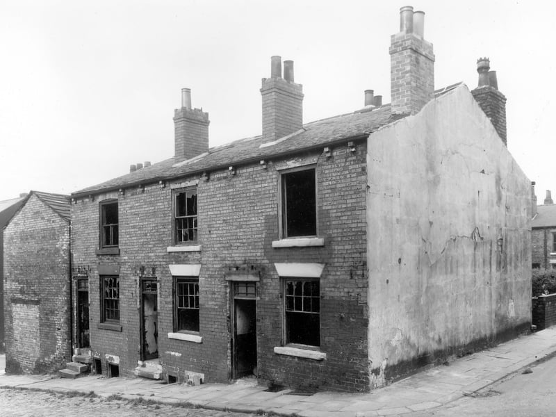 Back to back brick built terraced houses numbered from left to right, 53A to 57 (Number 53 can be seen on another photograph of the street). These houses are in derelict condition as they await clearance. Far left are the bricked up shop premises of number 2 Haymount Terrace. Pictured in October 1958.
