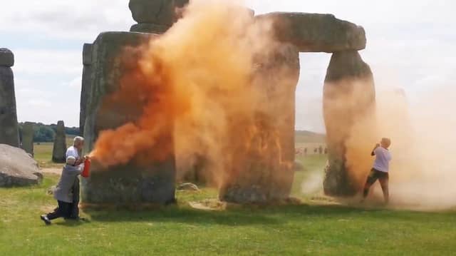 A screen grab taken from a handout video of Just Stop Oil protesters spraying an orange substance on Stonehenge