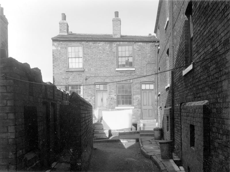Chippendale's Yard, a small enclave of houses situated between Dolly Lane and Primrose Place. Looking straight ahead, the house in the left is number 13 with number 11 on the right. These are back to backs. Almost at right angles to the right of the photograph, the numbers follow in descending sequence. Brick built toilet facilities can be seen left. Pictured in October 1958.