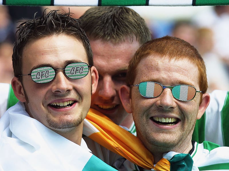 Two Celtic fans enjoy the summer sun during the pre-season game against Queens Park Rangers at Loftus Road in 2002.