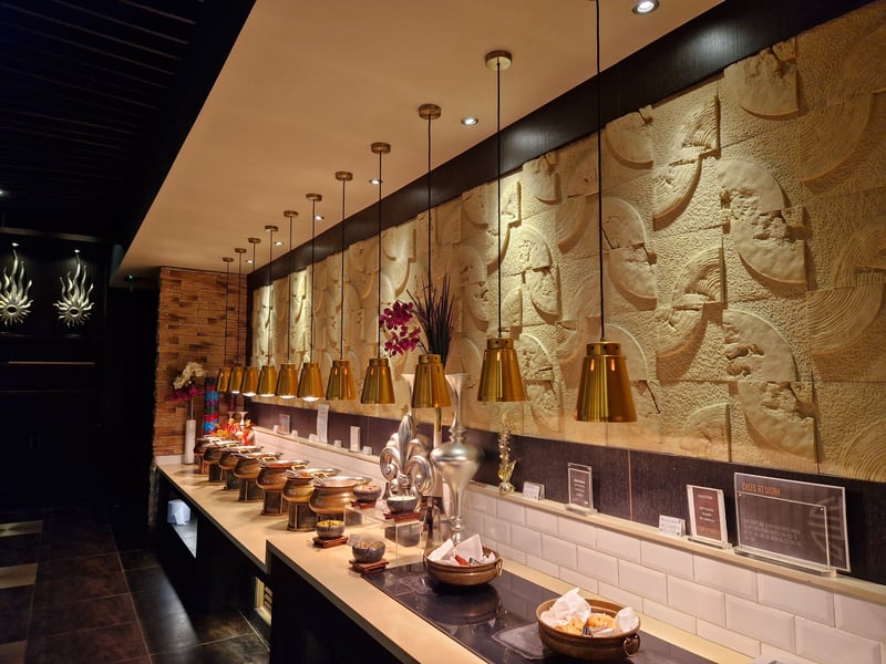 Honey stone walls are part of the beautiful restaurant which makes browsing cuisines, plate in hand, all the more delectable