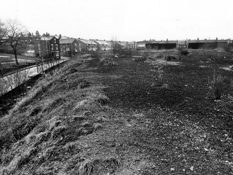 An area of wasteland on Oldfield Lane, which can be seen on the left; on the opposite side of the road is Wortley Recreation Ground. Housing can be seen further along the road, with more housing on Roseneath Street on the right. Pictured in January 1983.