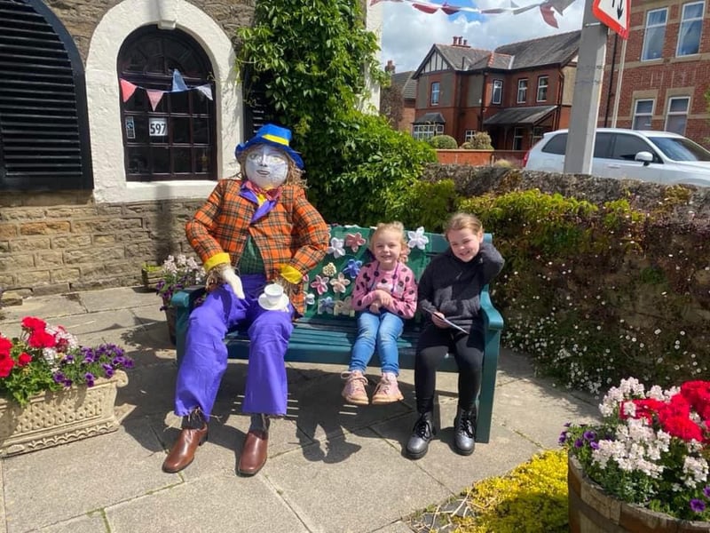 Attendees enjoy a sit down with a scarecrow