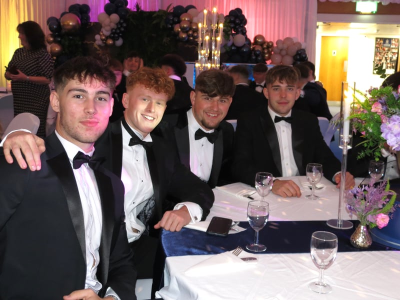 Four prom-goers smile for the camera ahead of their dinner