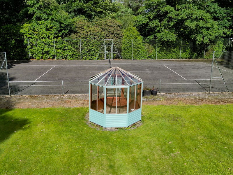 As well as its all-weather court, the grounds feature a large raised terrace, summer house and landscaped gardens, lawns and woodland, extending to nine acres.