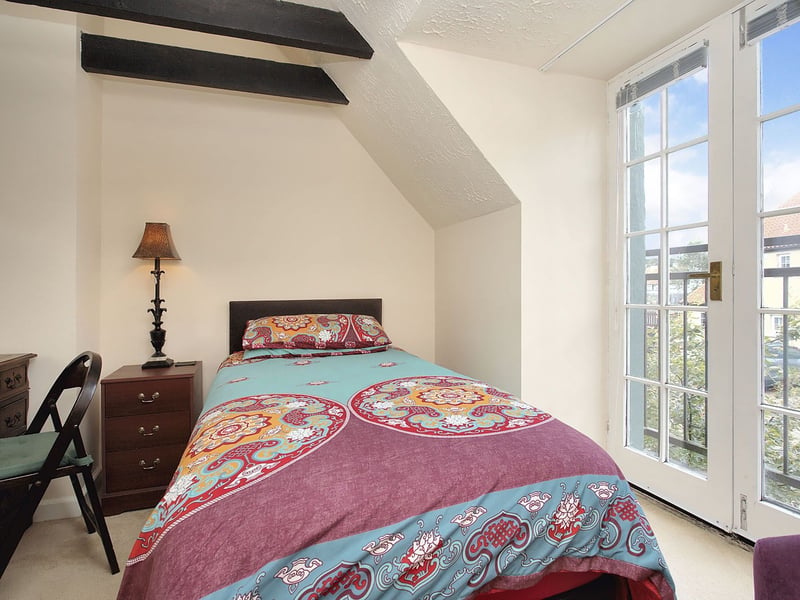 The East Lothian cottage's third double bedroom, complete with French doors to a Juliet balcony ensuring plenty of natural light into the room.