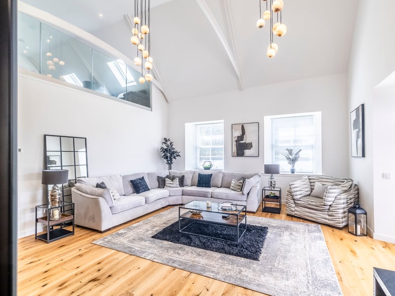 The bright lounge has a double-height vaulted ceiling plus wood-burning stove.