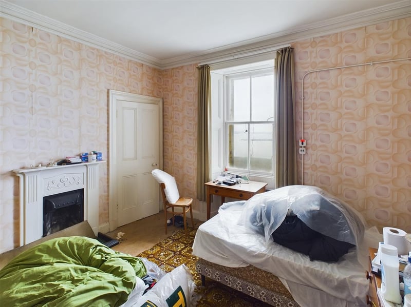 The original fireplace and built in storage, as well as the view, could make it a perfect primary bedroom.