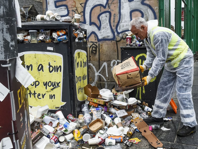 A bin - with an appropriate poster on its side - is overflowing with rubbish at the height of Edinburgh's festivals