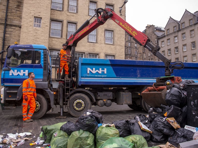 A refuse truck lifts collects piles of bin bags, after the waste strikes were finally called off in 2022