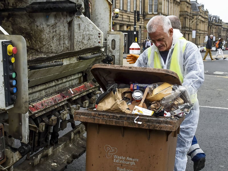 Workers pictured here cleaning up the waste after 12 days of strikes in Edinburgh in 2022