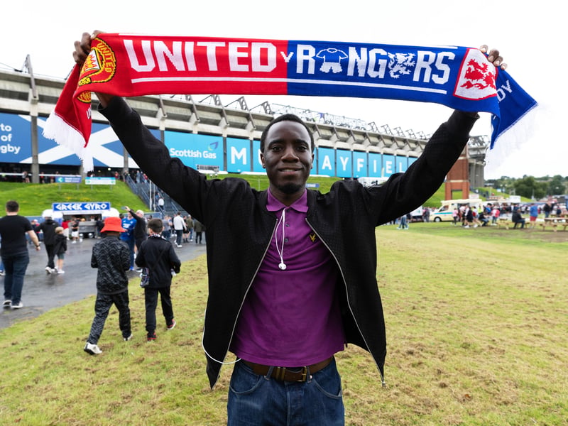 This fan raises his souvenir scarf above his head before the game.