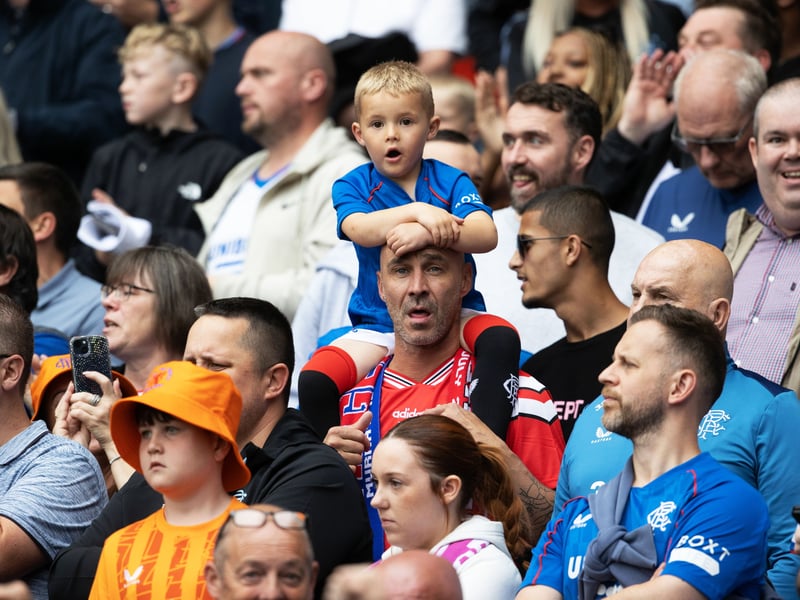 A young Rangers fan is giving a height boost in order to get a better view of the game against Manchester United.