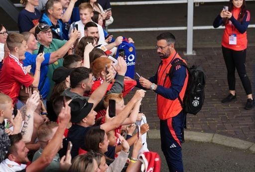 Manchester United's new coach Ruud Van Nistelrooy signs autographs before the game.