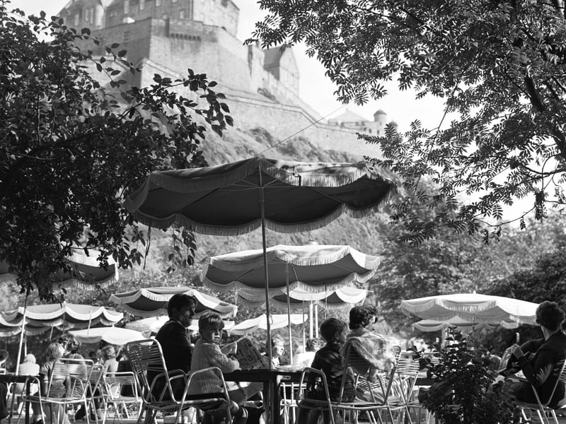People enjoying the summer sunshine at The Piazza open-air cafe in Princes Street Gardens Edinburgh in August 1970, with the Castle in the background.