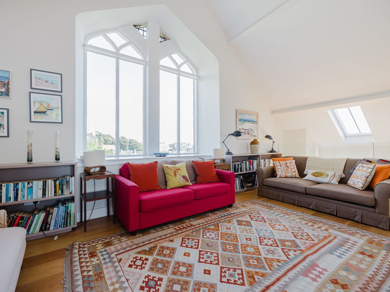 Up above are two mezzanine levels at either end, connected by a glazed walkway. With arched windows, handsome wooden flooring and a soaring ceiling providing a dramatic backdrop, the interior decor is sleek and minimalist.
