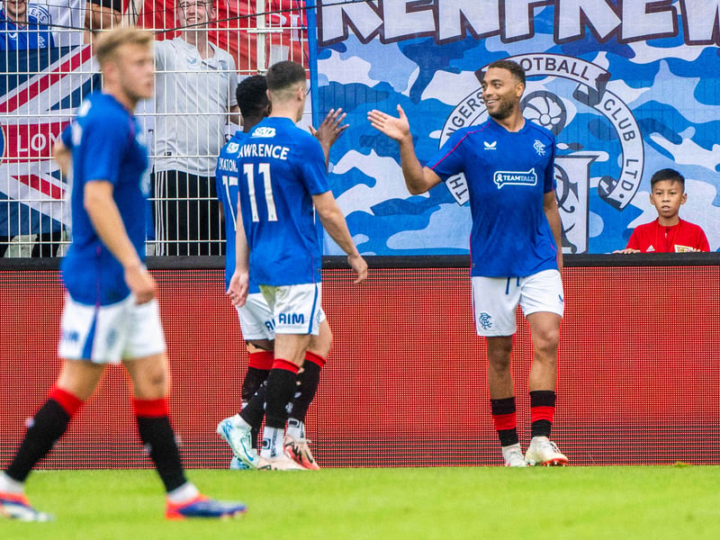 Supporters celebrate Cyriel Dessers' goal in Berlin alongside their flags.
