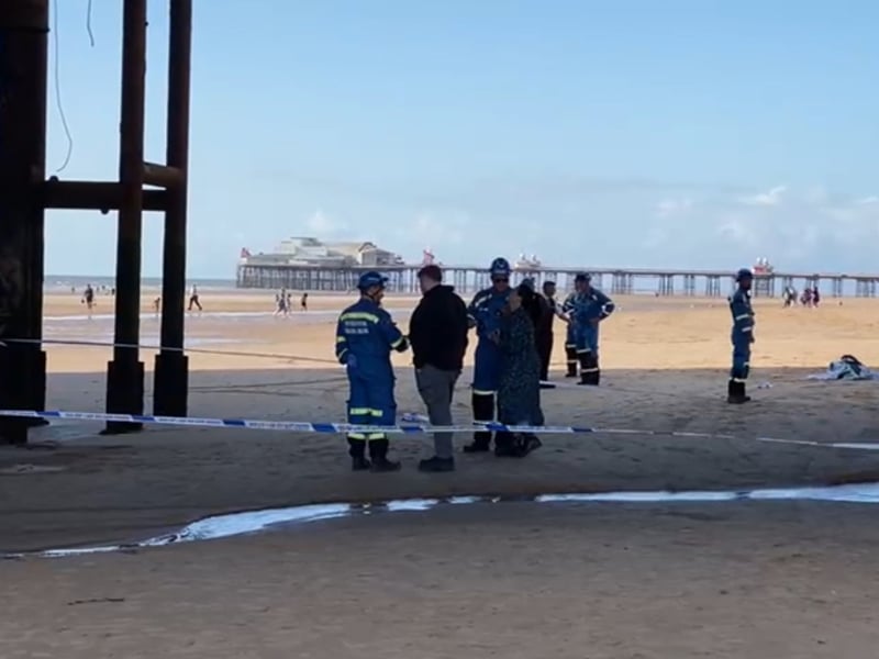Investigators below Central Pier in Blackpool after a woman falls through boards to the beach