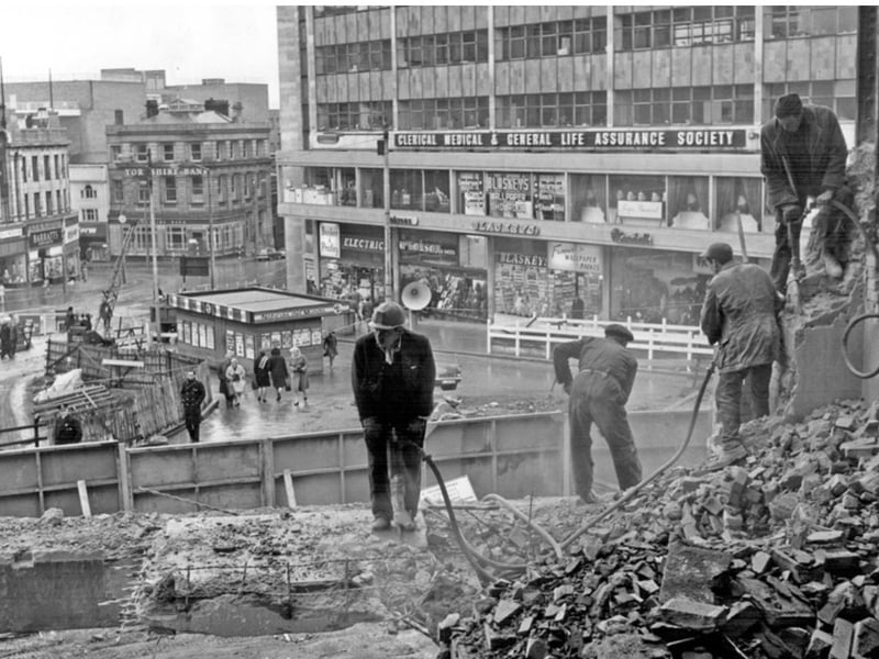 Construction of Sheffield's famous Hole in the Road subway and roundabout at Castle Square and Arundel Gate in February 1967. Workers are pictured reducing the size of J. Walsh and Co department store to allow for road widening.