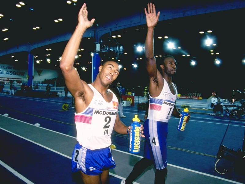 Colin Jackson #2 (left) and Linford Christie #1 (right) wave to the crowd after the 60 Metres event at the McDonalds International Games in Glasgow.