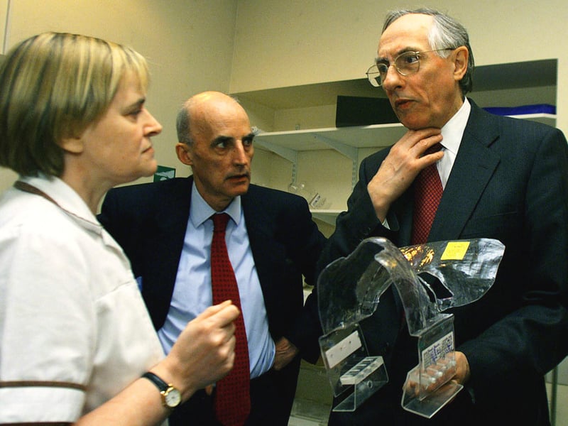 Britain's Secretary of state for Scotland Donald Dewar and health minister Sam Galbraeth speak to nursing staff at the Western Infirmary in April 1999.