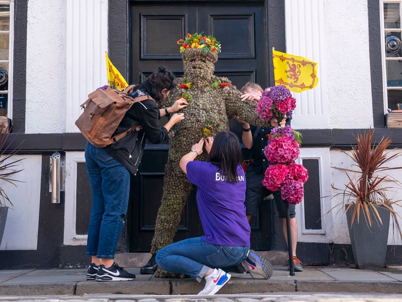 After emerging from the Stag Head Hotel on the High Street, the Burryman travels all the way to the waterfront by 6pm, near the Forth Bridge