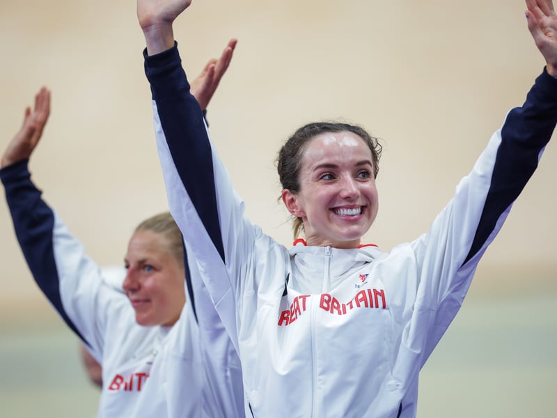 The duo celebrate on the podium after receiving the Olympic Silver for Women’s Madison, Track Cycling.