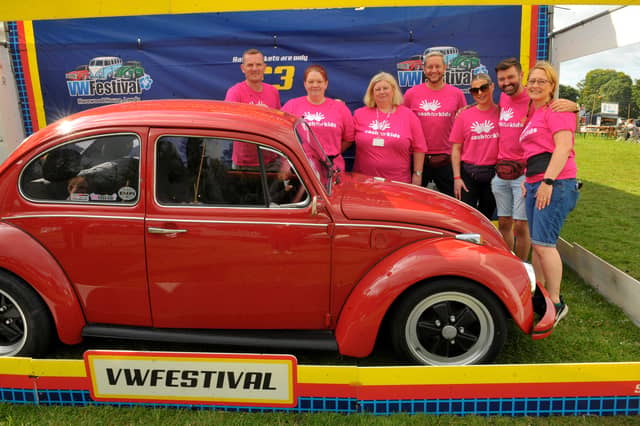 Staff and volunteers of Cash For Kids with the beetle renovated by the Beetle Hospital which was first prize in the raffle. This is the ninth car they have raffled at the festival raising over £100,000 for disadvantaged kids in Yorkshire. (pic by Steve Riding / National World)