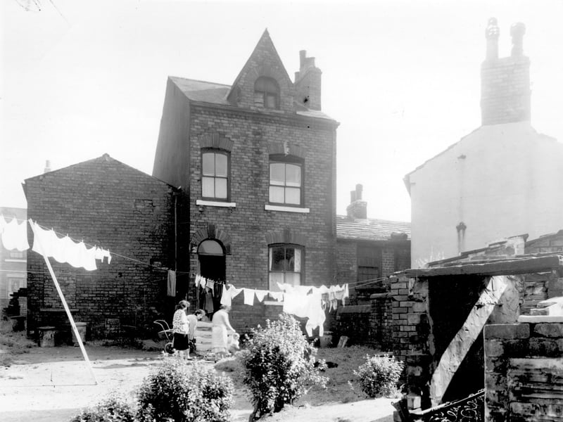 Number 6 Victoria Row, standing apart from other houses in the Row. There is a dormer window in the attic. A group of women and children are outside. Pictured in September 1958.