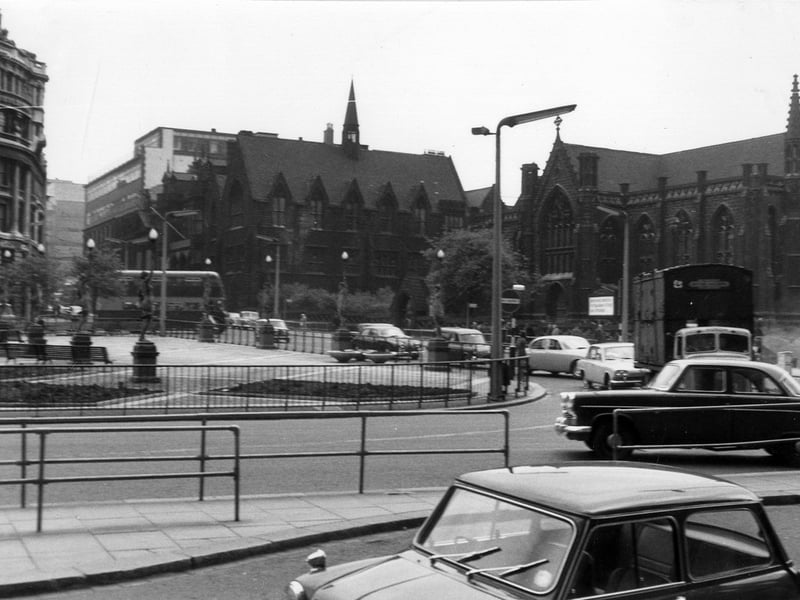 Park Row looking from in front of the Queen's Hotel in Wellington Street, near the junction with Boar Lane. At the left edge is the Norwich Union Building which stands between Infirmary Street and Park Row. The railings across the centre of the image surround City Square. Mill Hill Chapel in Park Row is at the right edge and the dark building in the centre with gables is Priestley House, now demolished.