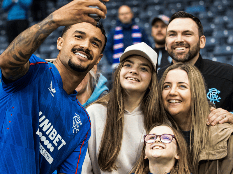 Jefte takes a selfie with a family of Rangers fans.