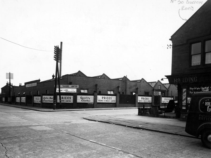 Burton Road with the junction with Garnet Road. Number 30 Burton Road is indicated in ink and is 'Harding, groceries and provisions'. There are some adverts for Combes Ale and Watheys Stout in the window of number 30 and a lorry parked outside. On the corner of Garnet Road and Burton Road is 'Prices Tailors Ltd, wholesale clothiers'. There are two telegraph poles on Burton Road. Pictured in September 1949.