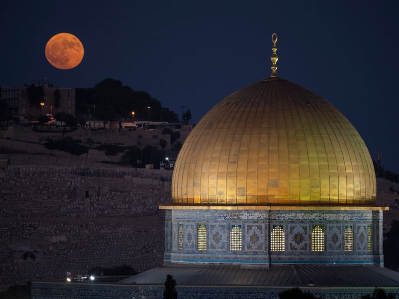 The supermoon rises behind the Dome of the Rock shrine at the Al Aqsa Mosque compound in the Old City of Jerusalem, Monday, Aug. 19, 2024
