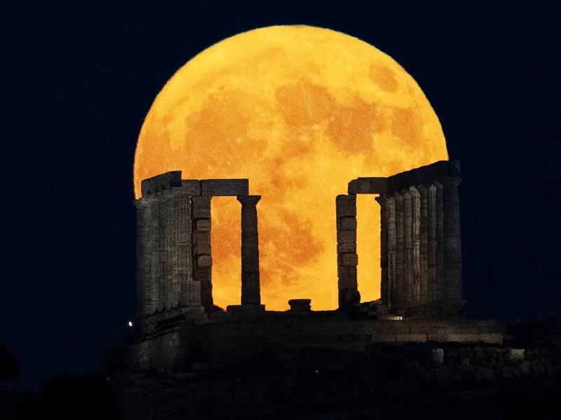 Supermoon rises behind the Temple of Poseidon at Cape Sounio, south of Athens, Monday, Aug. 19, 2024