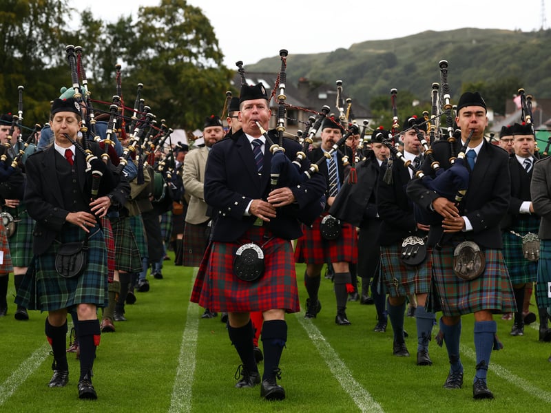 The pipe band and dignitaries march onto the field during the Argyllshire Gathering on August 22, 2024