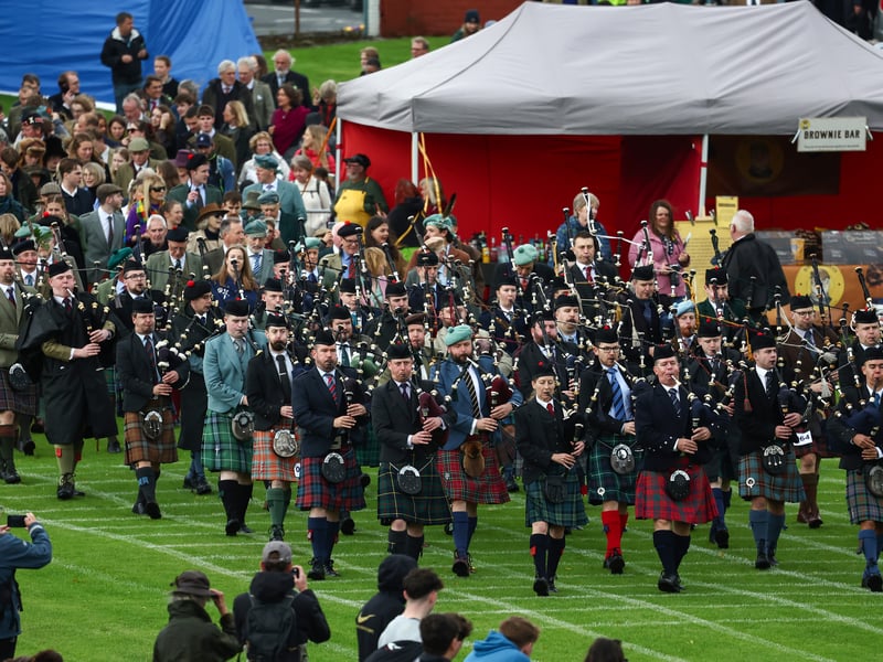 The pipe band and dignitaries march onto the field during the Argyllshire Gathering