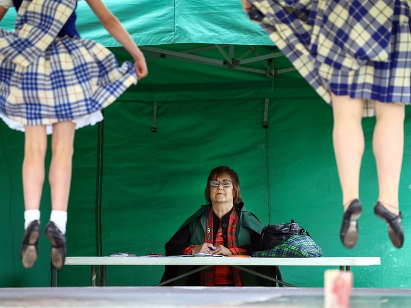 A judge watches dancers compete during the Argyllshire Gathering