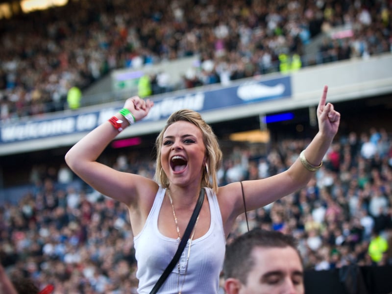 A fan takes to her fellow concertgoers shoulders for a better view.