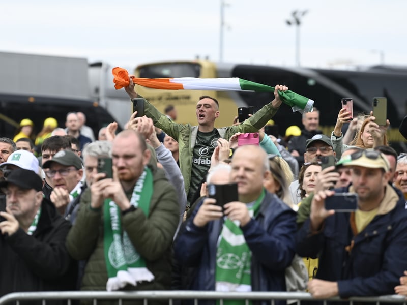 Some Celtic fans snap photos of the team as they arrive at the stadium.
