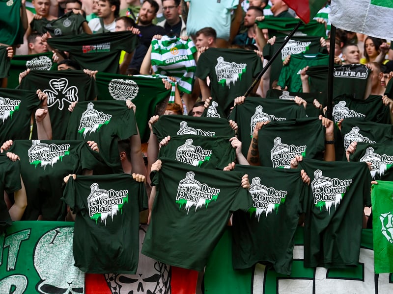 Celtic fans raise a shirt that says 'Dear Green Place' before the match kicks off.