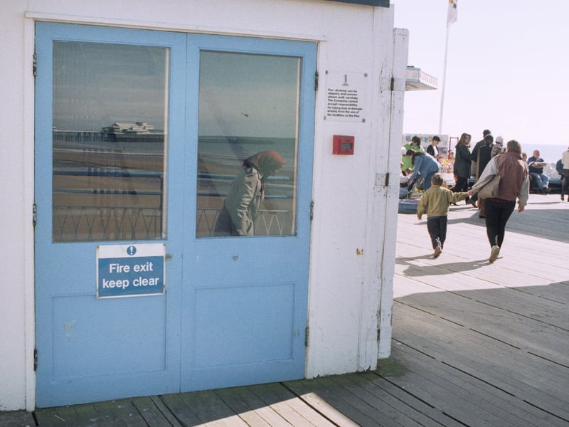 Reflection of lady in head scarf in building on Blackpool's Central Pier, 5th May 1996