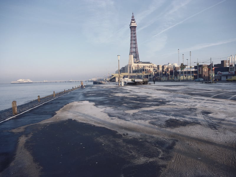 A couple of dog walkers in an otherwise deserted seafront in the seaside town of Blackpool, Lancashire, England, December 1982